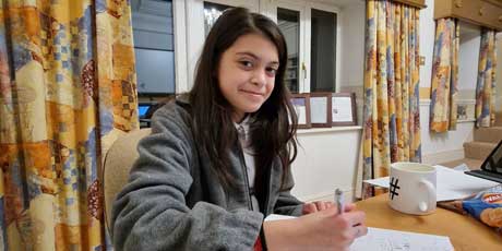 A pupil working confidently through her maths exercises during a lesson